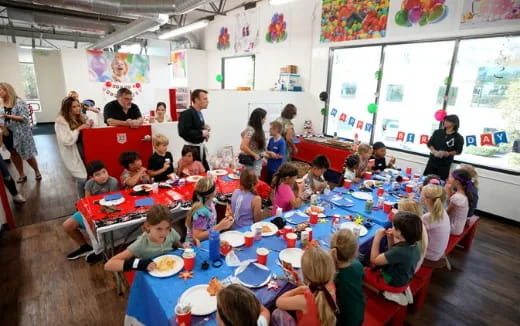 a group of children sitting at a table eating food