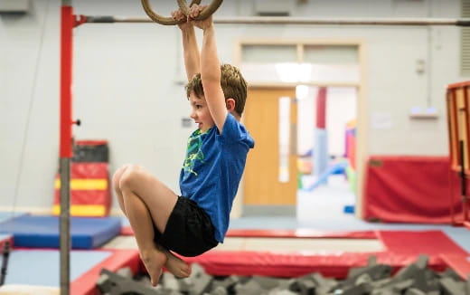 a boy doing a plank on a bar