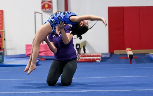 a woman doing a handstand on a mat