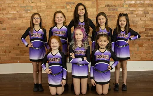 a group of girls in purple and black uniforms