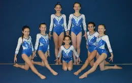a group of women in blue and white leotards on a stage