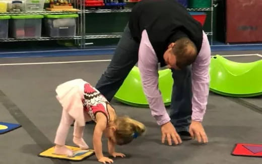 a person and a child doing push ups on the floor