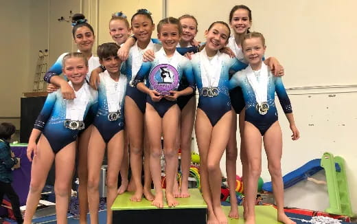 a group of girls in leotards posing for a photo