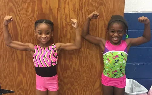 a couple of young girls flexing their muscles