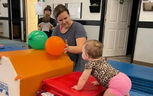 a person and a baby playing with balloons