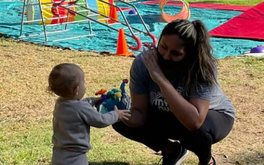 a person and a child playing with toys in a field