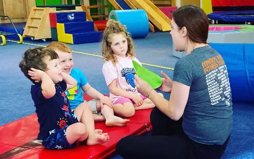 a person and several children sitting on the floor