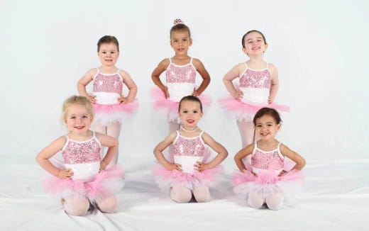 a group of children in pink dresses