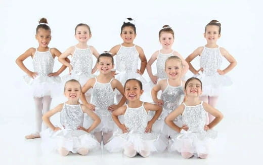 a group of girls in white dresses