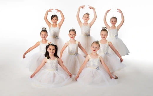 a group of women in white dresses