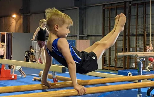 a boy doing a plank on a mat in a gym