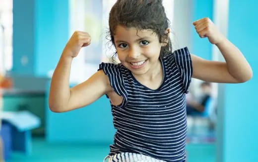 a young girl with her arms up