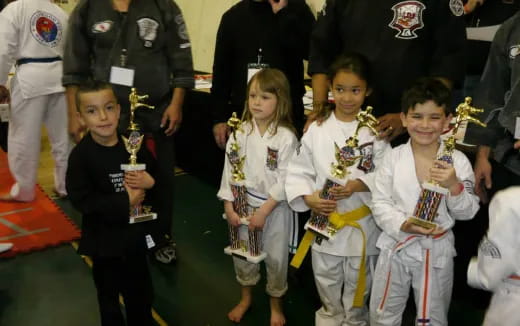 a group of children holding trophies