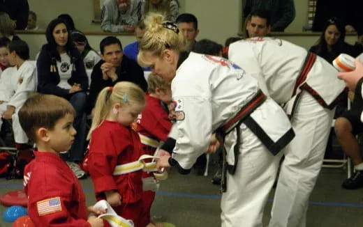 a person in a karate uniform with children