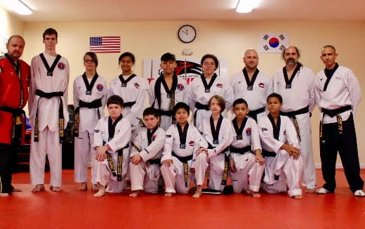 a group of people in white karate uniforms posing for a photo