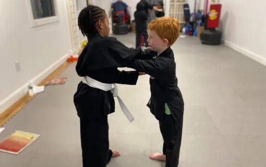 a person and a boy in black karate uniforms