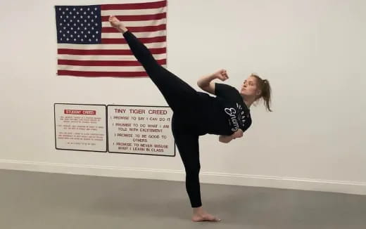 a woman doing a handstand in front of a flag