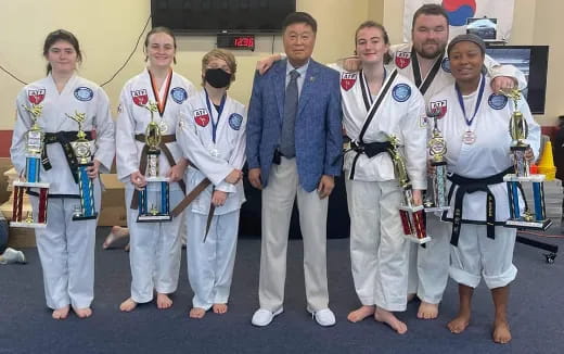 a group of people wearing white lab coats and holding trophies