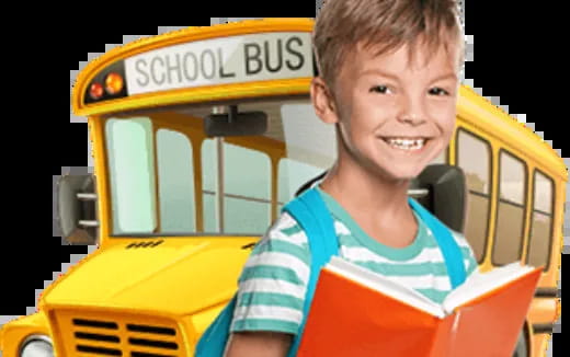 a boy smiling in front of a school bus