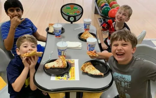 a group of boys eating pizza