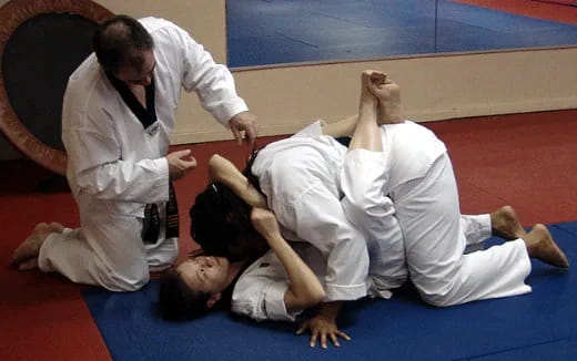 a group of people in white karate uniforms on a mat