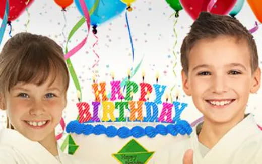a couple of kids smiling at the camera with a birthday cake