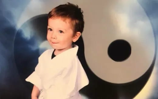 a child standing in front of a blue wall