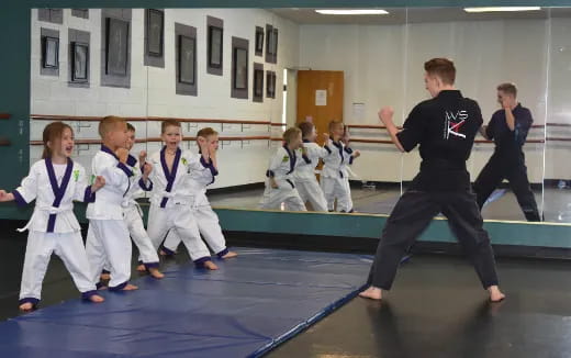 a group of children in karate uniforms