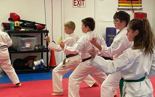 a group of people in white karate uniforms