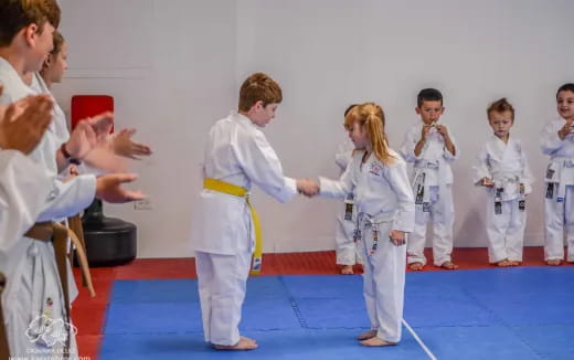 a group of people in white karate uniforms