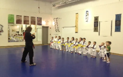 a man standing in front of a group of children in a classroom