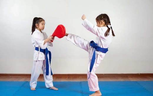 a couple of girls in karate uniforms