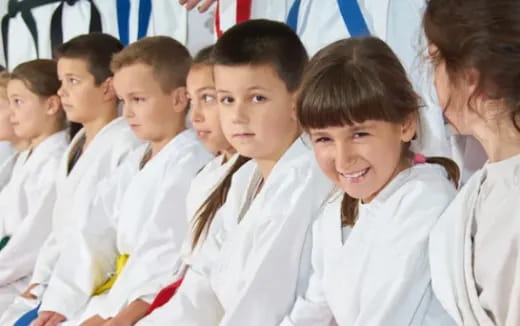 a group of children in white uniforms