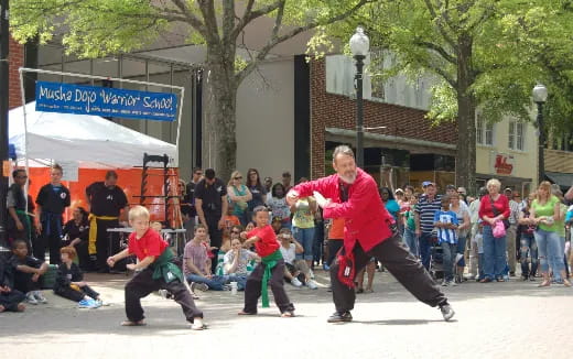 a person and a boy dancing in front of a crowd