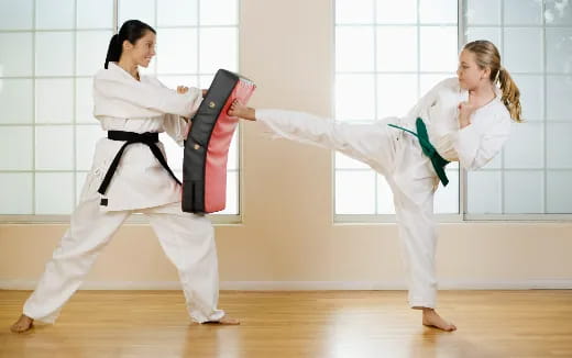 a couple of women in karate uniforms