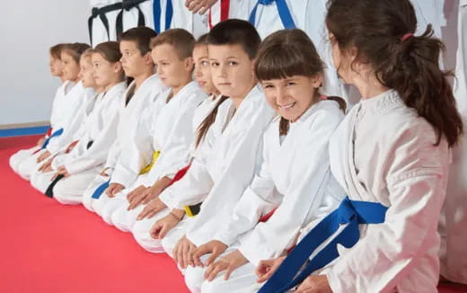 a group of children in white karate uniforms