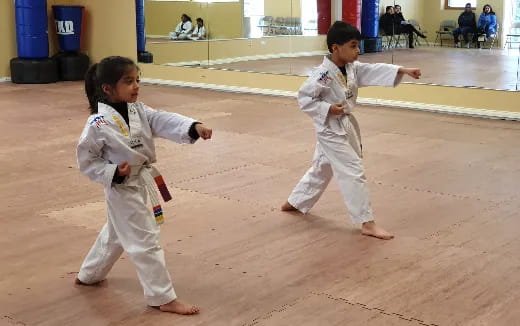 a couple of children in karate uniforms