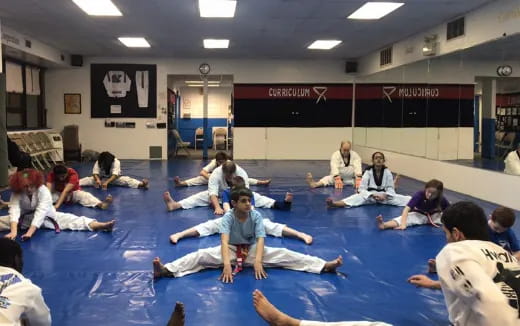 a group of people sitting on mats in a room