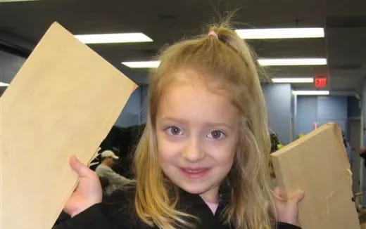 a girl holding a yellow paper bag
