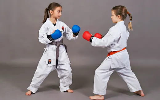 two girls wearing white karate uniforms