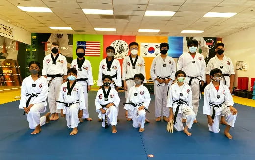 a group of people in white karate uniforms posing for a photo