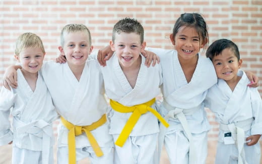 a group of children in white karate uniforms