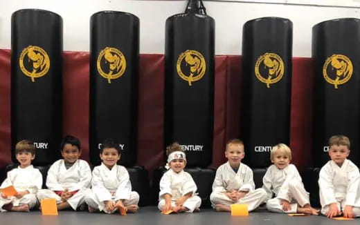 a group of children sitting in front of a row of speakers