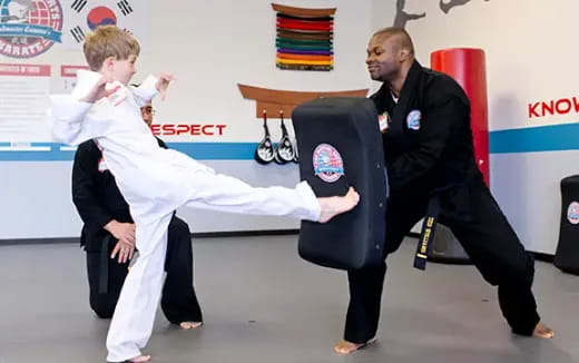 a person in a karate uniform with a boy in a suit