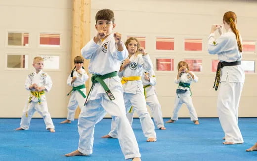 a group of children in karate uniforms