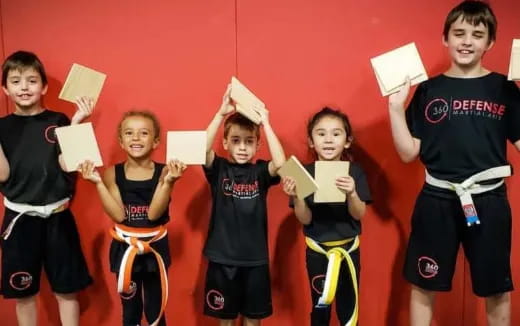 a group of children holding up paper