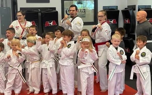 a group of children in white karate uniforms