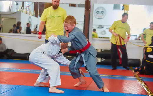 a man and a boy in karate uniforms on a mat