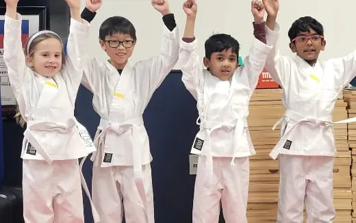 a group of kids in karate uniforms