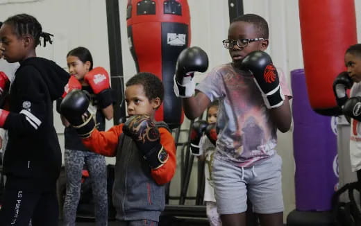 a person with boxing gloves and a boy in a boxing ring